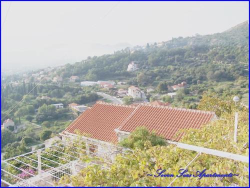 a view of a town with houses and a mountain at Seven Seas Apartments in Mlini