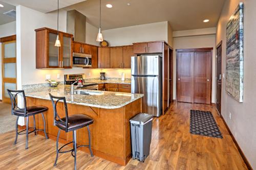 a kitchen with a counter and a refrigerator at Breezy Lake Chelan Condo with Pool and Hot Tub Access! in Manson