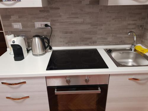 a kitchen with a stove and a sink at Appartamento Rosalba in Asti