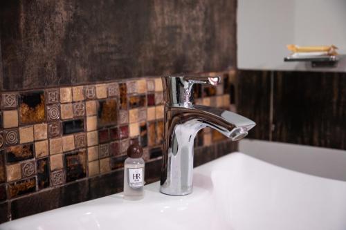 a bathroom sink with a faucet and a bottle of soap at Hotel Rulman in Puerto Maldonado