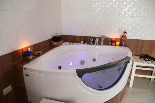 a large white bath tub in a bathroom with candles at Hotel Rulman in Puerto Maldonado