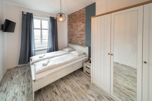a bedroom with a bed and a brick wall at Around the World Vision Apartment - Centrum in Opole