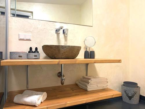a bathroom with a bowl sink on a wooden shelf at Villa Kitzbühel in Kirchberg in Tirol