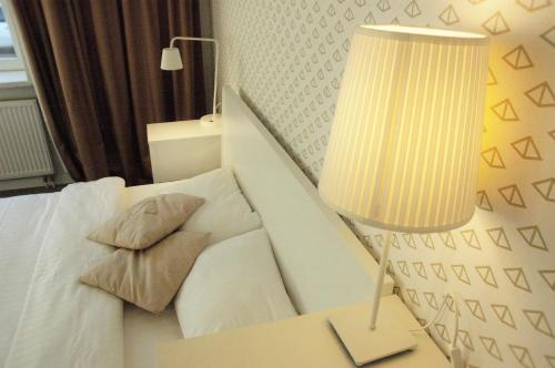 a bedroom with a bed and a lamp on a table at SAKÀ Vacation House in Druskininkai