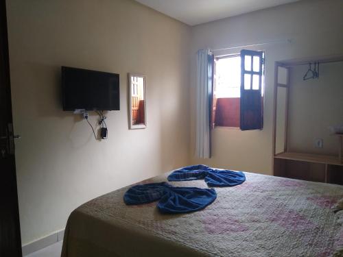 1 dormitorio con 1 cama y TV de pantalla plana en Hospedaria Casa de Adriana en Lençóis