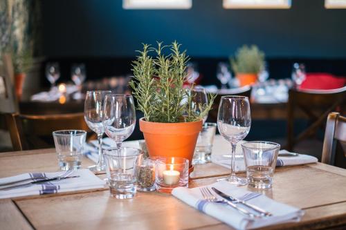 uma mesa com copos de vinho e uma planta em vasos em The Black Boy em Oxford