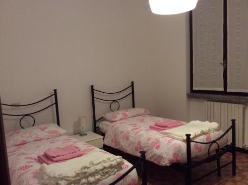 2 camas en un dormitorio con sábanas rosas y blancas en A CASA DI TERRY, en Vaprio dʼAdda