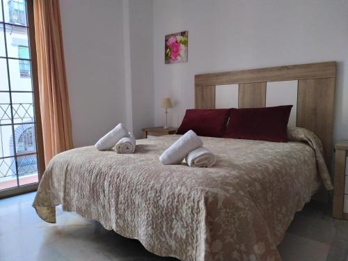- une chambre avec un grand lit et des serviettes dans l'établissement Precioso apartamento en el Arenal, à Séville