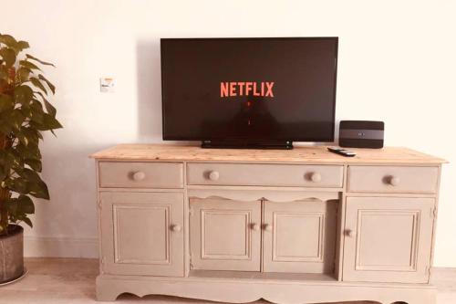 a television on top of a white dresser at Olympic Village Vela - Portland in Portland