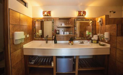 a bathroom with a sink and a mirror at Pura Vida Hotel in Alajuela
