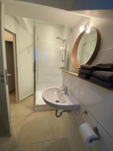 uma casa de banho branca com um lavatório e um espelho em BS Living Ap am Zoo em Braunschweig