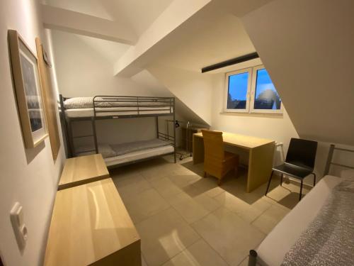 Zimmer mit Etagenbetten, einem Tisch und einem Schreibtisch in der Unterkunft BS Living Ap am Zoo in Braunschweig