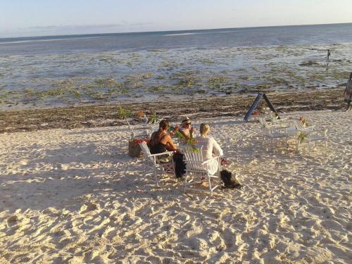 a group of people sitting in chairs on the beach at BeB Sardegna2 Anjumasa village in Watamu