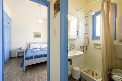 a small bathroom with a bed and a sink at Agnanti Studios in Naousa