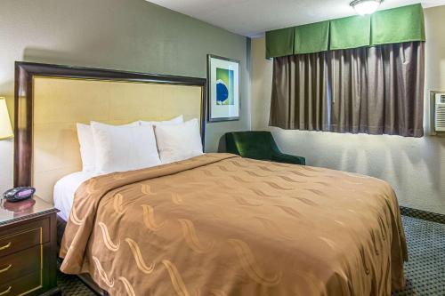 um quarto de hotel com uma cama grande e uma cadeira em Roosevelt Hotel em Williston