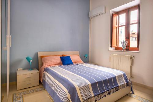 sypialnia z łóżkiem i oknem w obiekcie La Casa di Sara a Mondello w mieście Mondello