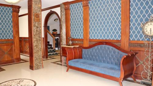 a blue couch in a room with a clock on the wall at Hotel Florida in Ambato