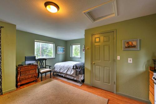 a bedroom with green walls and a bed and a window at Seward Studio with Deck, Outdoor Dining and Mtn Views! in Seward