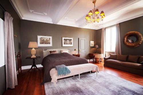 - une chambre avec un lit, un canapé et un lustre dans l'établissement La Résidence de Gérard, à Montréal