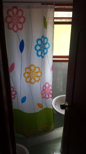 a bathroom with a shower curtain with flowers on it at HOSPEDAJE BELLA VISTA MONGUI in Monguí