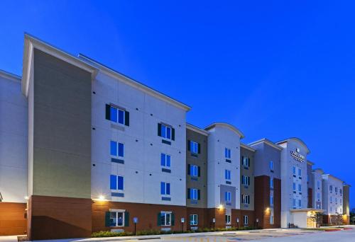 a row of apartment buildings at night at Candlewood Suites Houston - Spring by IHG in Houston
