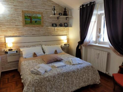 - une chambre avec un lit et des serviettes dans l'établissement Luxury Apartment Magnolia Terrace, à Fregene