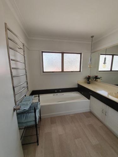 a bathroom with a bath tub and a sink at Kerikeri Central House in Kerikeri