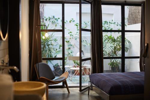 a bedroom with a bed and a window and a chair at Bubusuites in Valencia