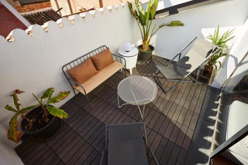 einen Balkon mit einem Sofa, einem Tisch und Stühlen in der Unterkunft Bubusuites in Valencia