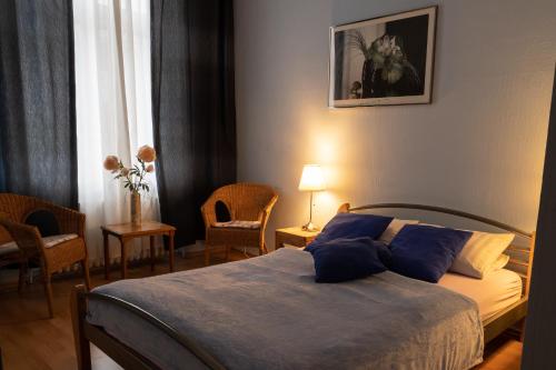 a bedroom with a bed with blue pillows at Hotel-Pension Charlottenburg in Berlin