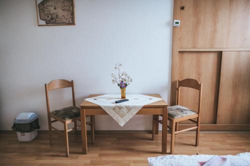 a table with two chairs and a vase of flowers on it at Klub U Námořníka in Dvůr Králové nad Labem
