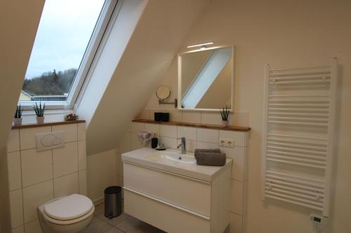 a bathroom with a sink and a toilet and a window at CASA STROBL in Landsberg am Lech