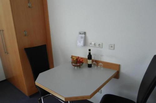 a white table with a bottle of wine on it at Apartment-Haus in Cologne