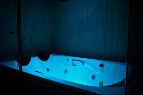 a bath tub with a blue light in a bathroom at Hotel Saron in Luziânia