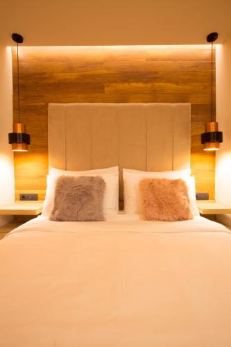 a bedroom with a large white bed with two pillows at Adryades luxury apartments in Metsovo