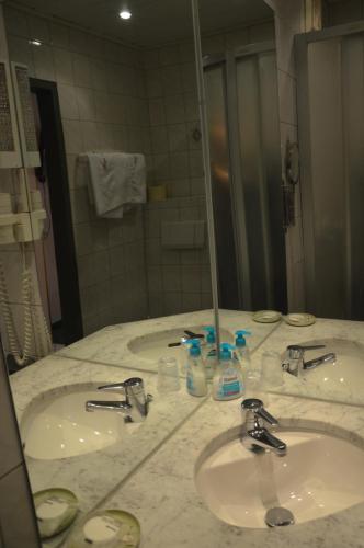 a bathroom with three sinks and a large mirror at Haus Frey in Sankt Johann im Pongau