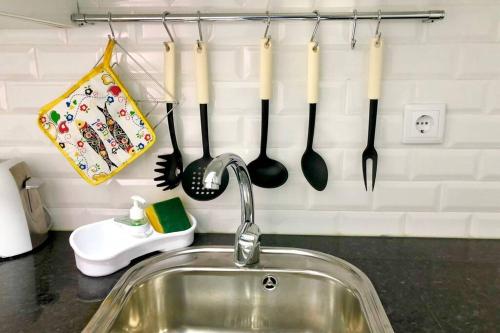 eine Küchentheke mit einer Spüle und Küchenutensilien an der Wand in der Unterkunft Heart of Lisbon Private Apartment, Bairro Alto in Lissabon