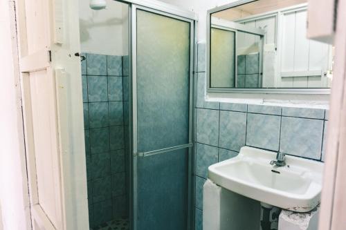 a bathroom with a shower and a sink and a mirror at Cabinas EL PRADO in San Isidro