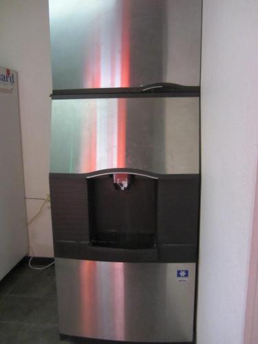 a stainless steel refrigerator in a room at Travelodge by Wyndham Pecos in Pecos