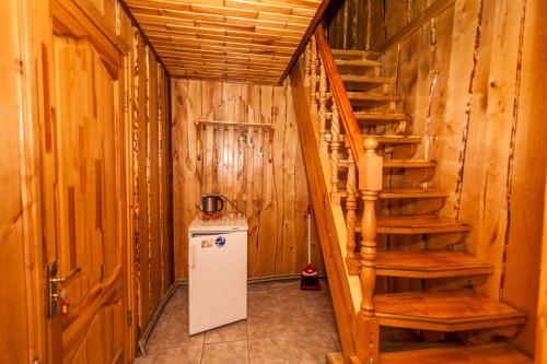 a room with a staircase and a small refrigerator at Smerekova Hata in Yablunytsya