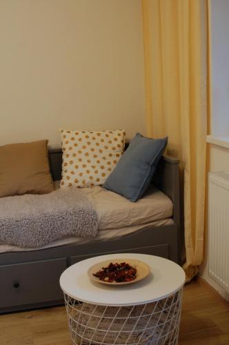 a room with a couch with a table with a plate on it at Apartman Masaryk in Lipova Lazne