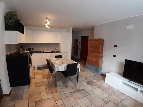 cocina con mesa y sillas en una habitación en Appartamento a Dimaro in Val di Sole, en Monclassico