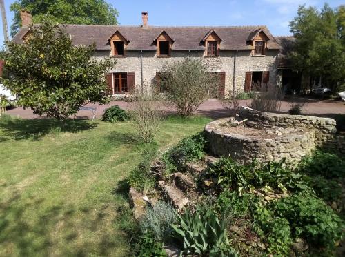 an old house with a garden in front of it at Accueil chaleureux in Crannes-en-Champagne