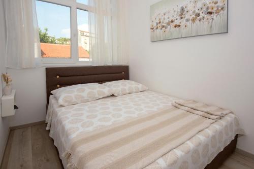 a bedroom with a bed in a room with a window at Sibenik city center Apartment Sonia in Šibenik
