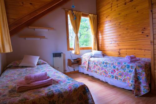 a bedroom with two beds and a window at Paillahuen in Villa La Angostura