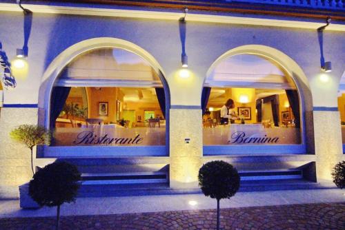 a restaurant with two arched windows in a building at Hotel Bernina in Tirano