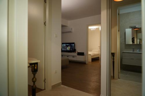 a hallway with a room with a bed and a television at Jackey apartment in Banja Luka