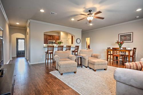 a living room with chairs and a table and a kitchen at College Station Townhouse with Private Patio in College Station