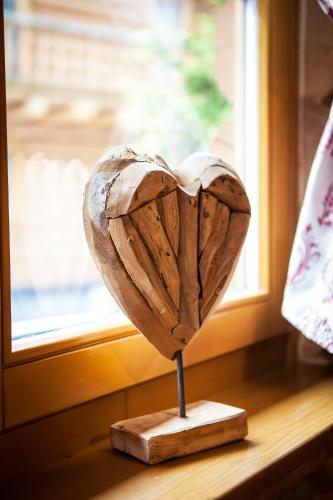 a wooden heart on a stand in front of a window at Zruby Bystrá, Chopok Juh in Bystrá