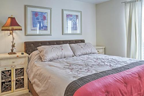 a bedroom with a bed and a table with a lamp at Las Vegas Condo with Patio, Pool, Gym about 1 Mi to Strip in Las Vegas